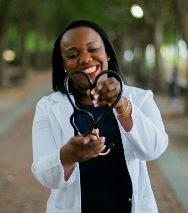 Smiling healthcare professional forming a heart shape with a stethoscope