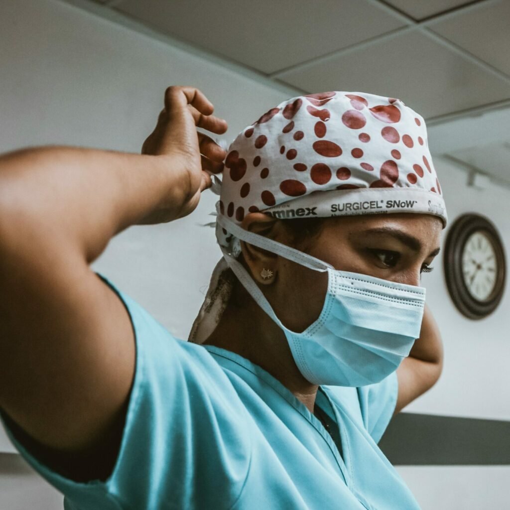 Nurse adjusting her protective face mask in a hospital setting