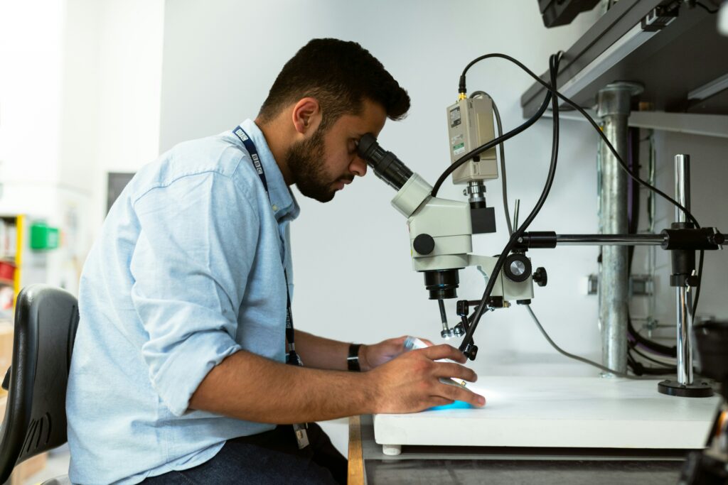 Biotech researcher examining samples under a microscope in a laboratory